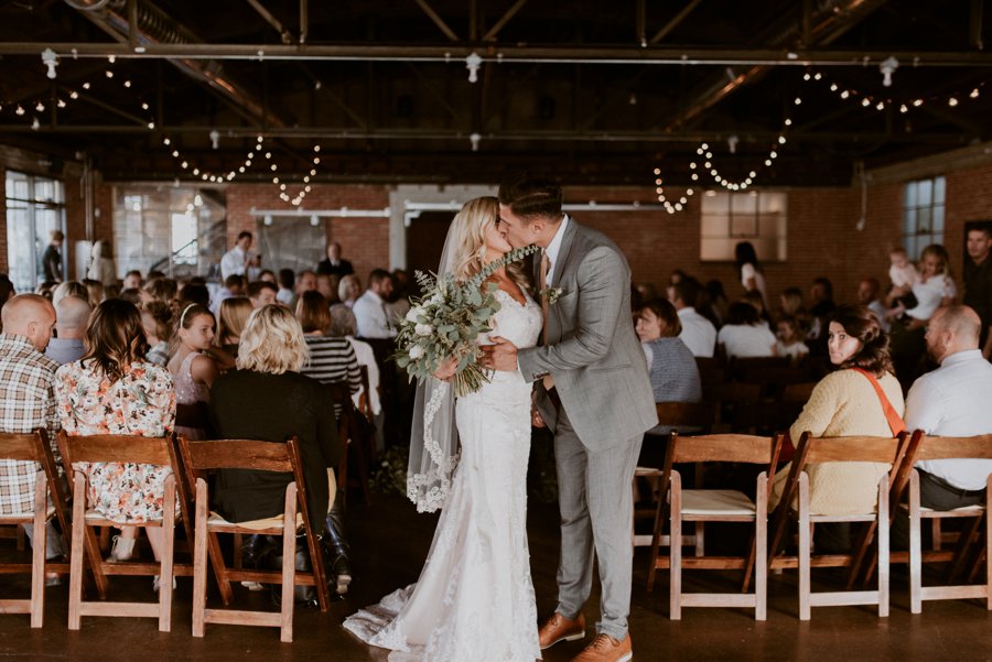 A bride and groom kiss at their Publik Coffee wedding