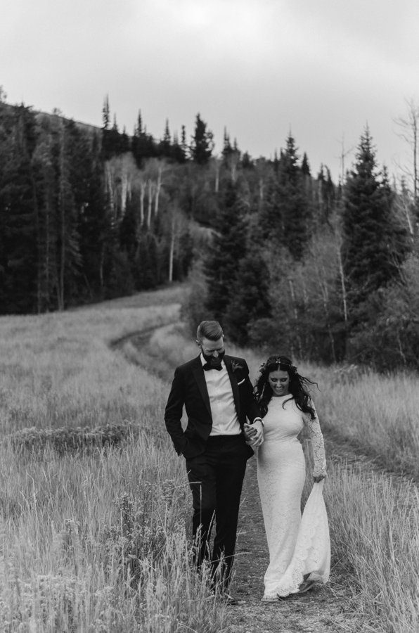 Black and white photo of Bride and Groom walking outside at the St Regis Deer Valley