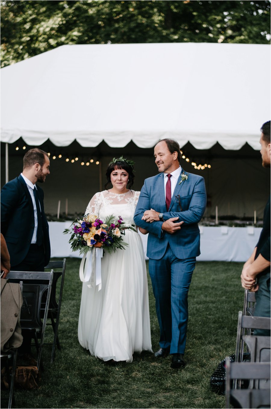 Emotional wedding day photo of bride walking down the aisle with her dad