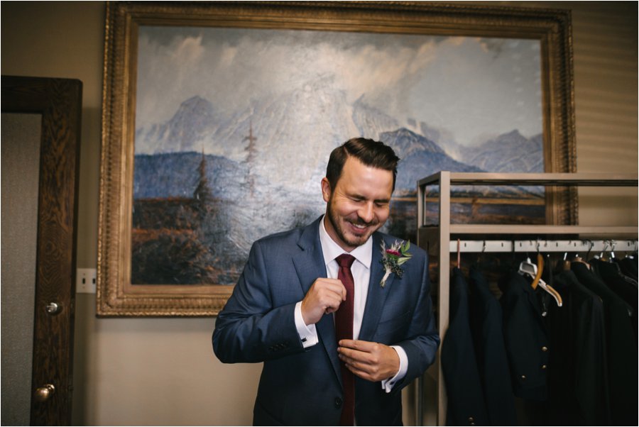 Laughing groom getting ready at his wedding.