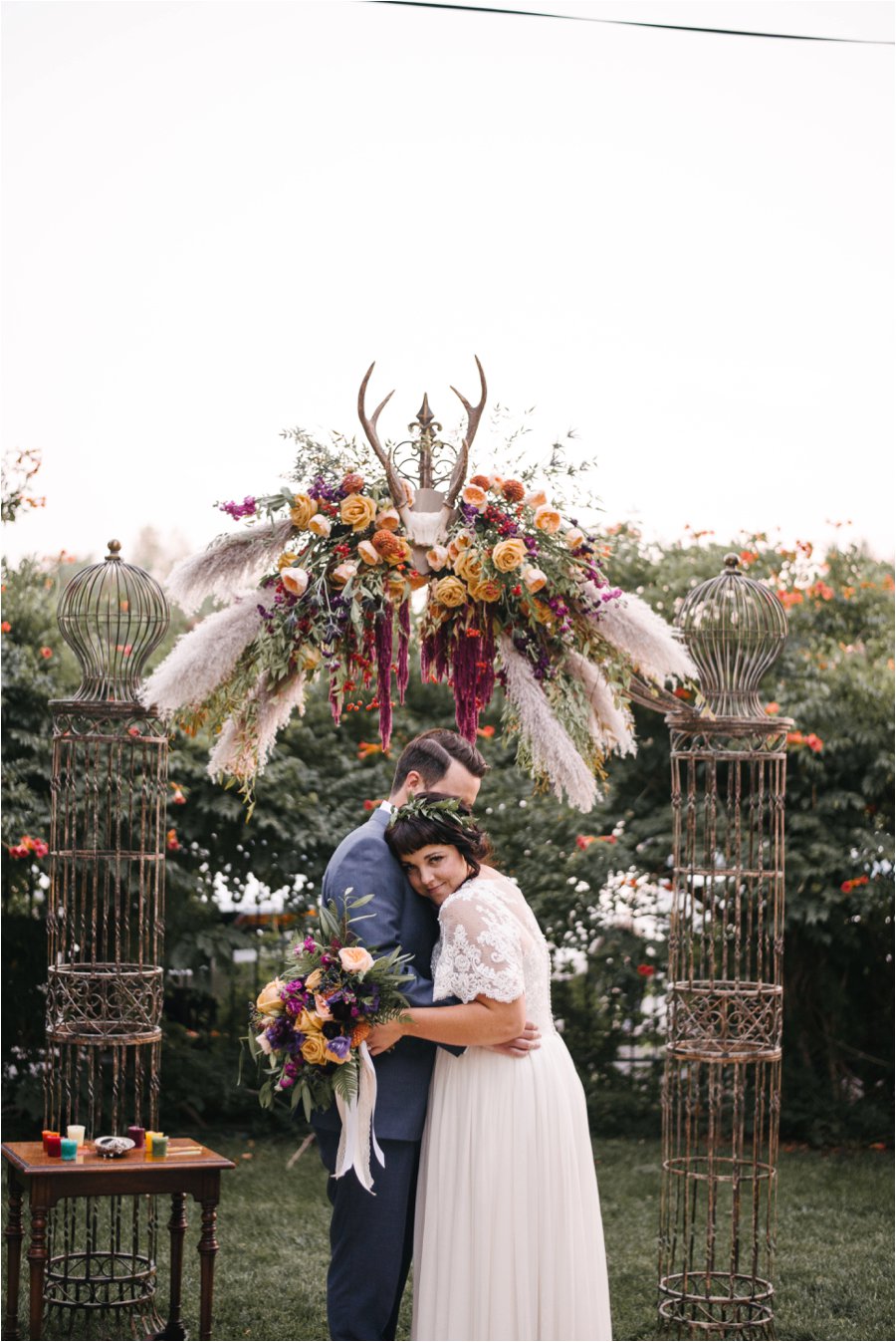 Bride and Groom first kiss under fall floral archway