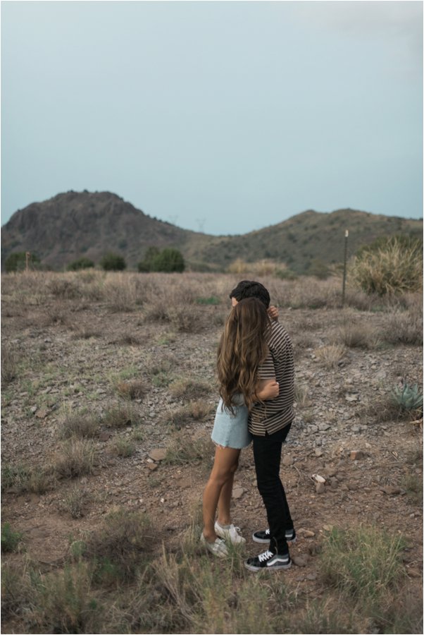 Film style photo of couple hugging in the desert after dusk.  